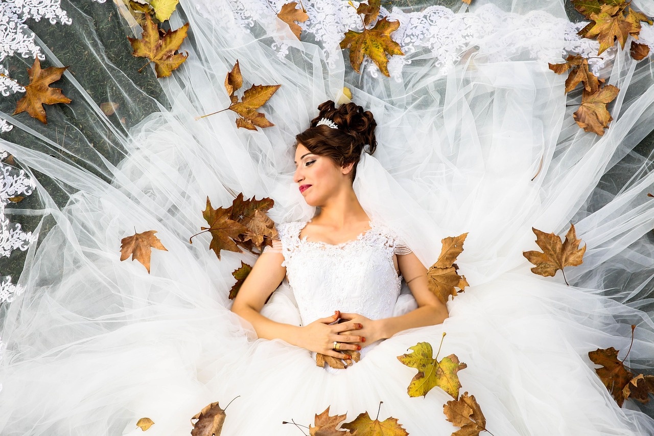 Novia tumbada con el vestido y el velo desplegados
