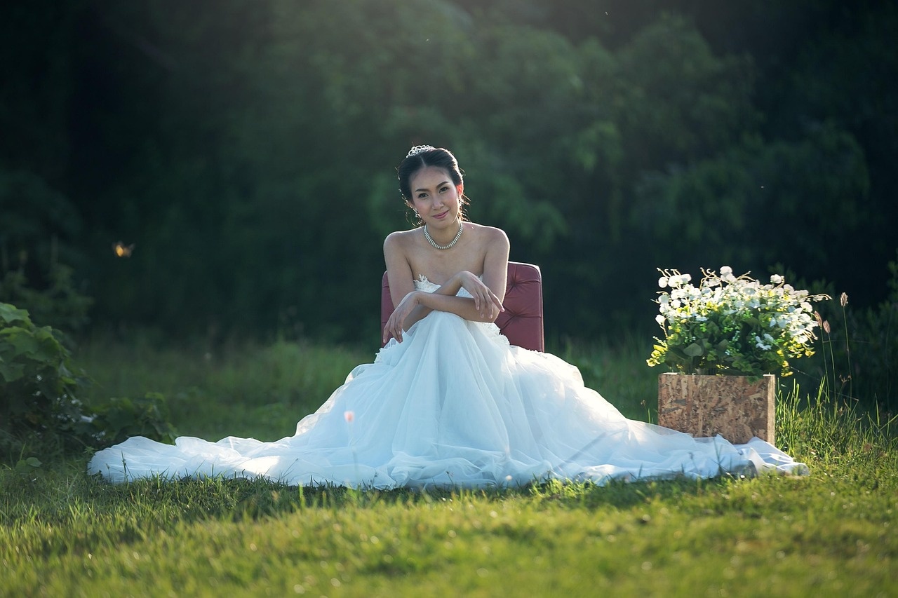 Novia sentada en un prado al atardecer